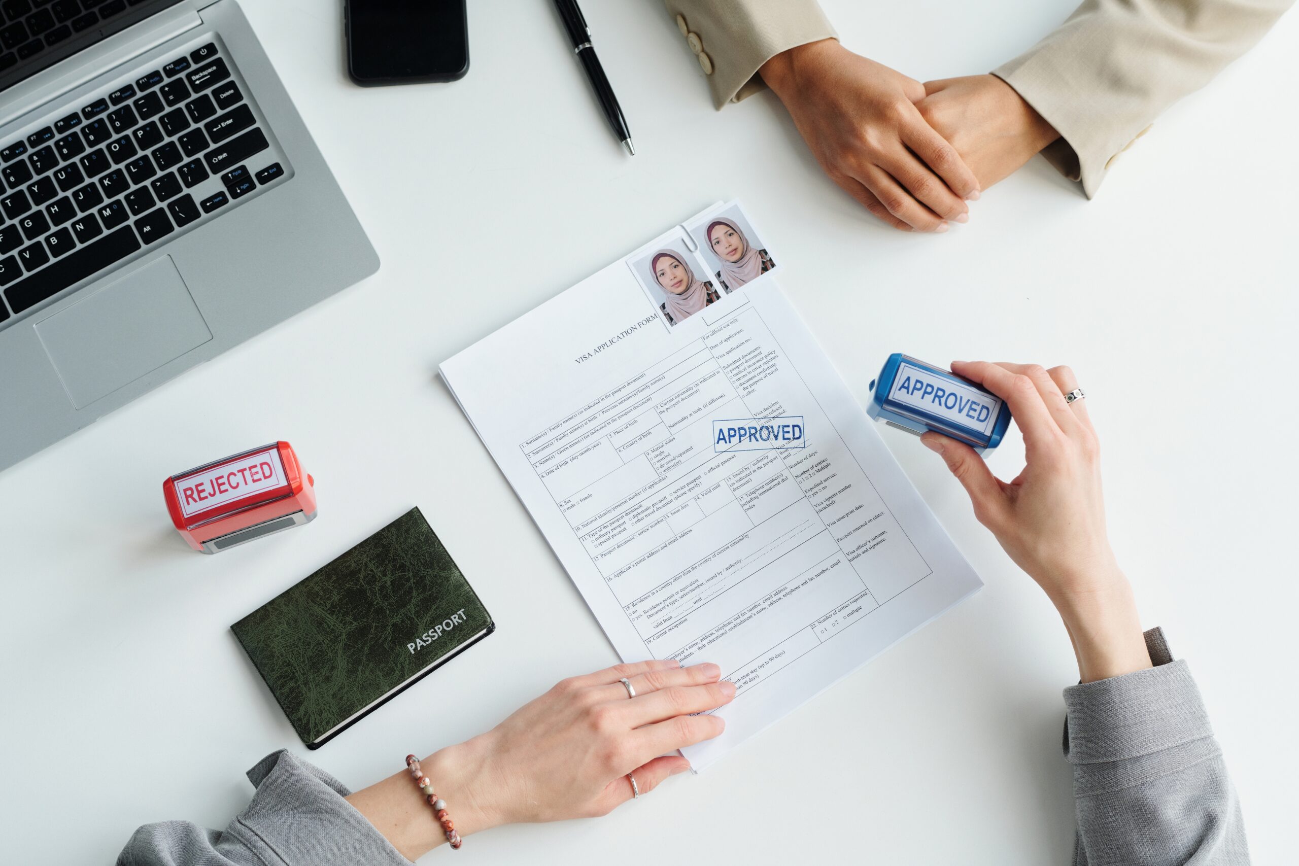 Professional immigration consultants working with a diverse family reviewing visa documents and world map in a modern consultation room