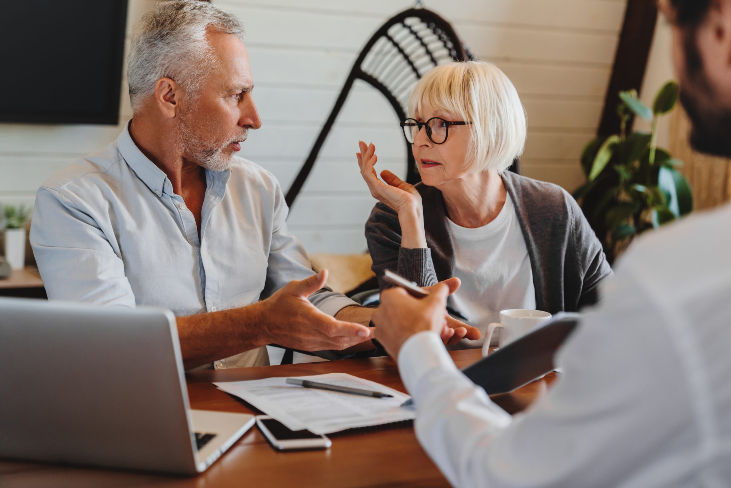 Professional immigration consultants working with a diverse family reviewing visa documents and world map in a modern consultation room